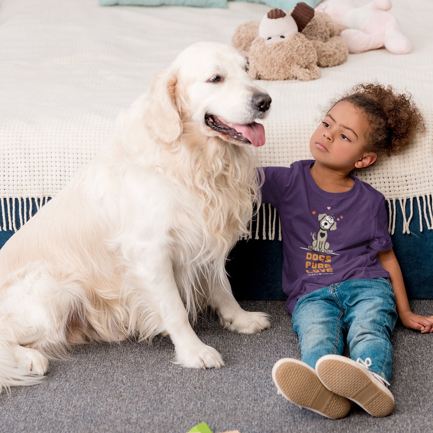 A young girl, dressed in a Dogs Pure Love purple tee, sits on the floor tenderly patting her Golden Retriever.