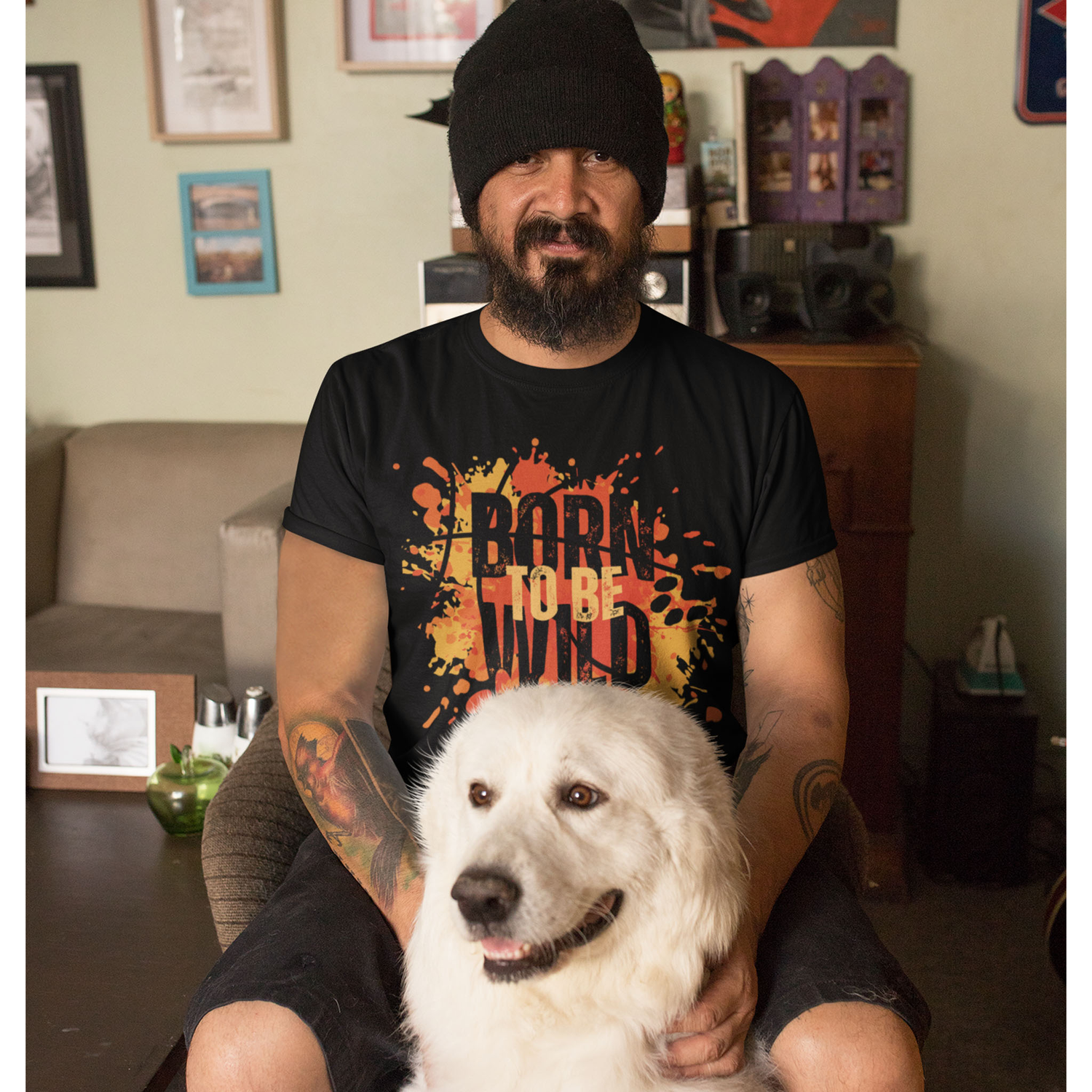 A steadfast man sits proudly sporting a "Dogs Pure Love" shirt adorned with the 'Born to be Wild' design, his loyal dog seated faithfully in front of him