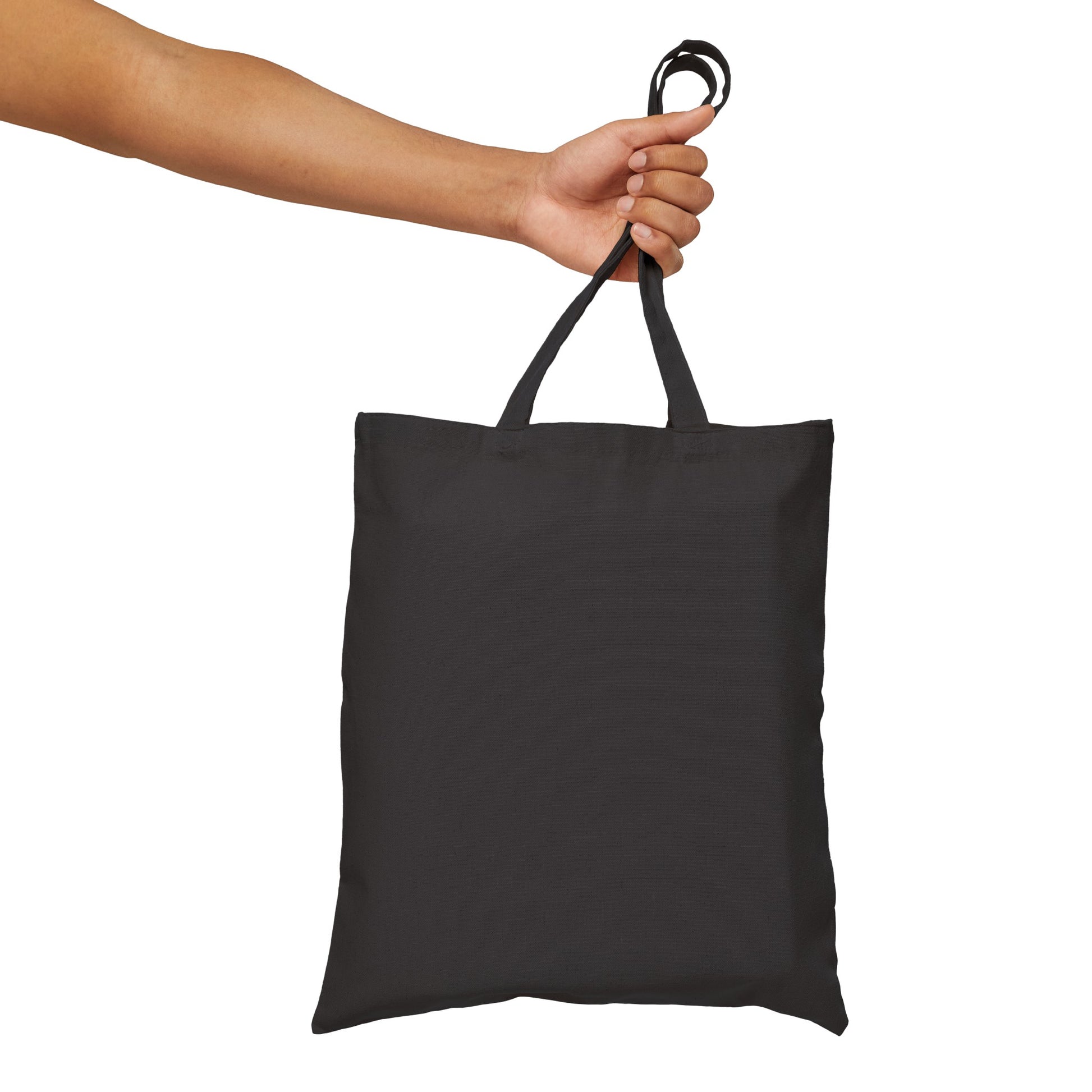 Against a white background, an extended arm holds a Dogs Pure Love tote bag, revealing the back of the bag with no print.