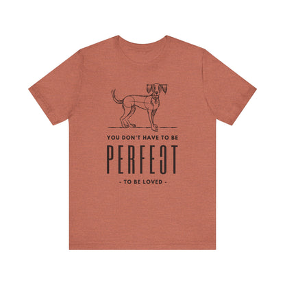  The Dogs Pure Love unisex t-shirt in heather clay elegantly presents the empowering slogan 'You don't have to be perfect to be loved,' set against a pristine white backdrop.
