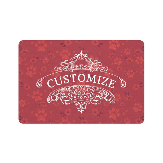 A red dog bowl mat features daisies and paw print design. A white elegant emblem displays text for you to choose from that connects to your dogs unique personality. The mat is against a white background.