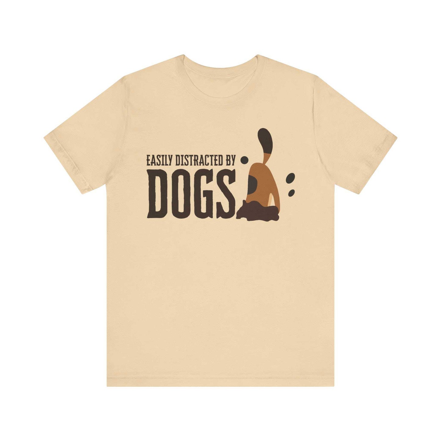 Amidst a white setting, a Dogs Pure Love soft cream unisex t-shirt features a fun slogan ‘Easily Distracted by Dogs,’ and a graphic of a dog digging.