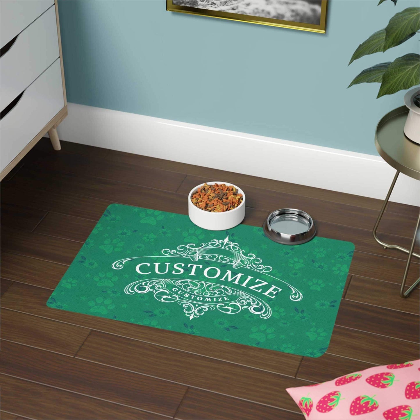 Green dog bowl mat with daisies and paw print design. A white customize graphic display element is beautifully crafted to display your dogs personality.  The scene  is in a living room with a bowl of biscuits and water sitting on the mat.