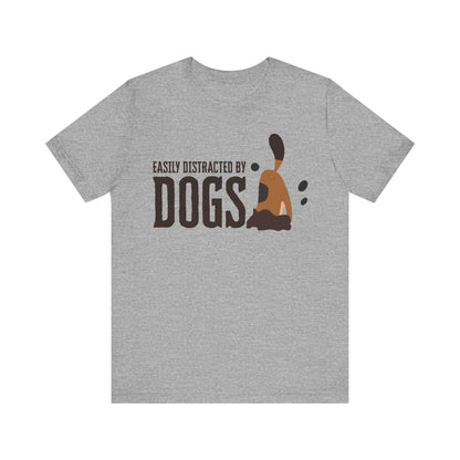 On a white surface, a Dogs Pure Love athletic heather colored unisex t-shirt features a playful slogan ‘Easily Distracted by Dogs,’ and a graphic of a dog digging.