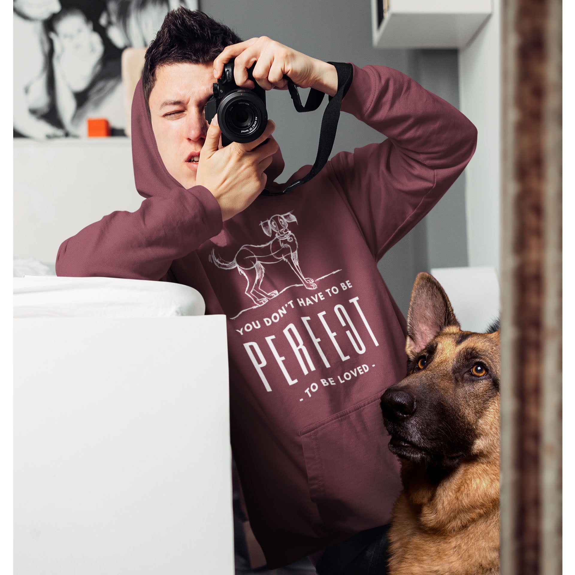  A man takes a photo of himself in the mirror while wearing a Dogs Pure Love 'Unperfected' hoodie, with his German Shepherd looking at him in the reflection.