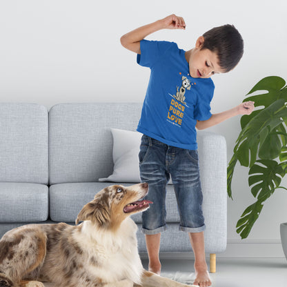  A boy wearing a blue Dogs Pure Love tee stands in front of a couch, looking down at his Australian Shepherd.