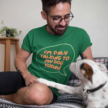 A man sits on a sofa looking lovingly at his dog. He is wearing a green t-shirt with the words "I'm only talking to my dog today!"