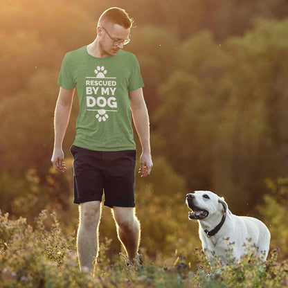  A man, clad in a leaf green Dogs Pure Love tee adorned with the words 'Rescued by my Dog' and pawprints, strolls alongside his Labrador in a field of flowers.