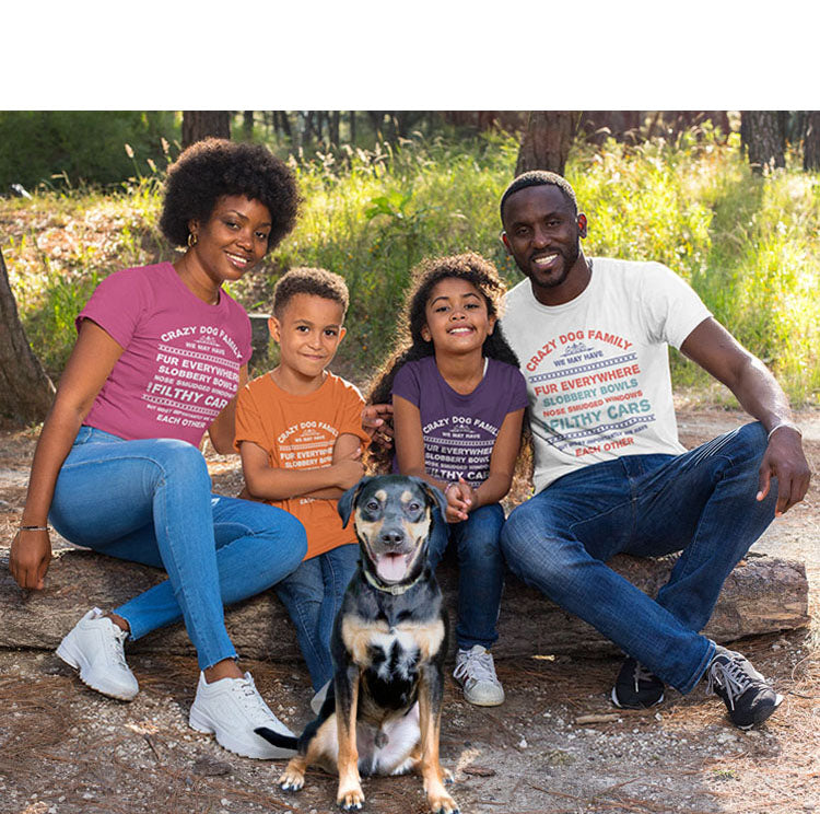  A family, all adorned in Dog Pure Love tees featuring the print 'Crazy Dog Family,' sits on a log with their dog in the center.